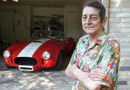 Rob La Gesse relaxes in the garage at home with his Cobra sports car.