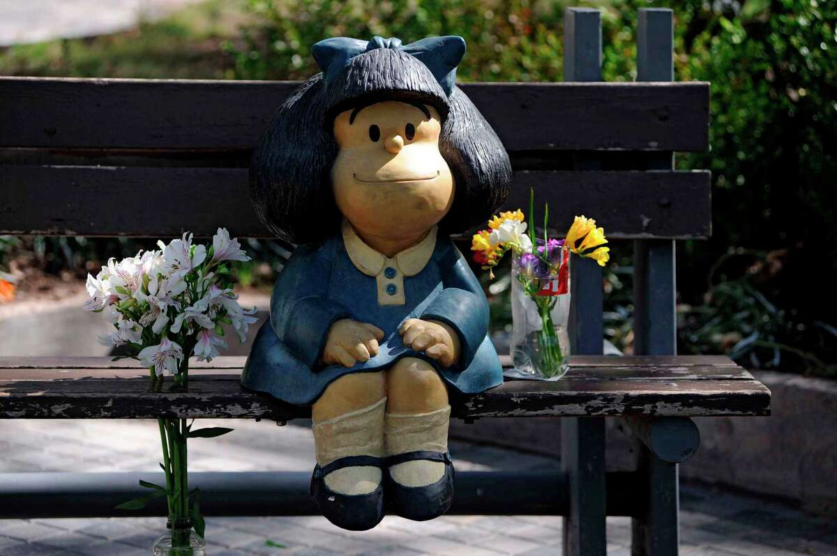 Un ramo de flores es visto junta a una estatua de Mafalda, un personaje de caricatura creado por el caricaturista argentino Joaquín Salvador Lavado, mejor conocido como “Quino”, en Mendoza, Argentina, el 30 de septiembre de 2020, el día de su fallecimiento. Quino falleció ese día a la edad de 88 años.