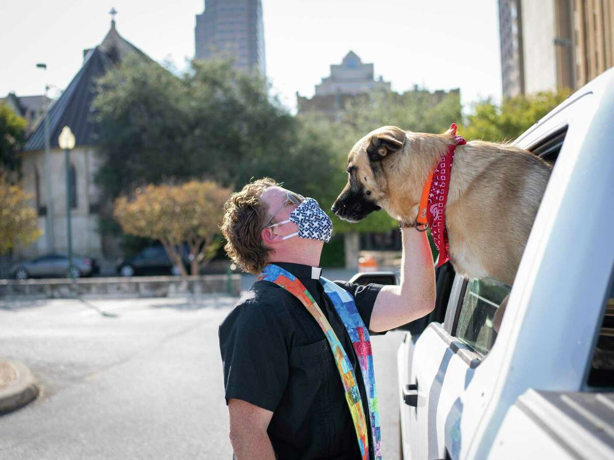 The Reverend Matthew Wise blesses David and Linda Hulett?•s dog Woody through their car window during an animal blessing put on by the clergy of St. Mark?•s Episcopal Church in San Antonio, TX, U.S. on Sunday, October 4, 2020. ?’Part of the excitement and joy of thisÉis with everything going on right now in our country and in the world with all the bad newsÉ this is some good news.,?“ Reverend Matthew Wise said. ?’This is a moment of joy to share with each other, particularly with a community that hasn?•t been able to come together. There?•s a joy just in the blessing itself and in seeing one another?•s pets.?“