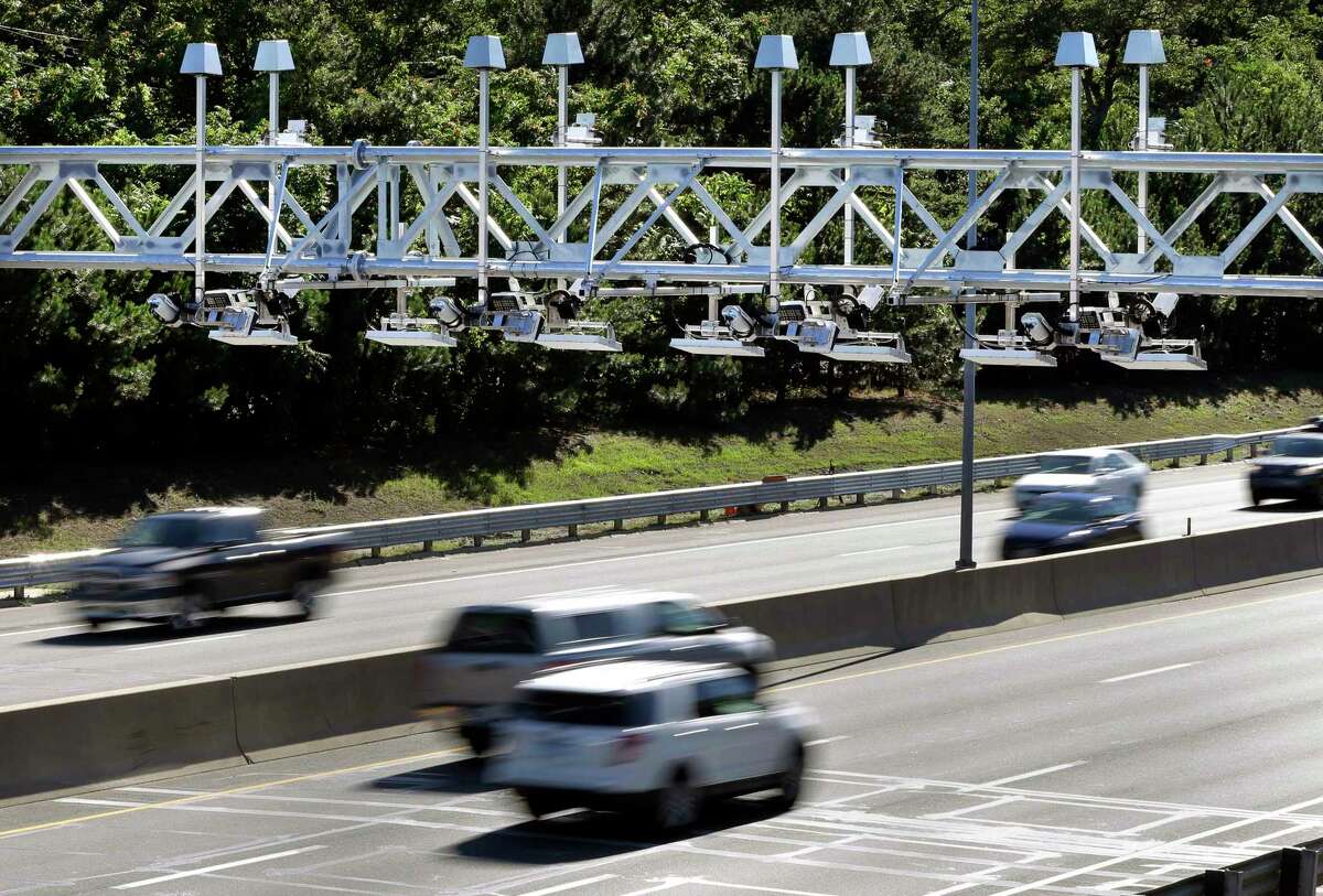 In this Aug. 22, 2016 file photo, cars pass under toll sensor gantries hanging over the Massachusetts Turnpike in Newton, Mass.