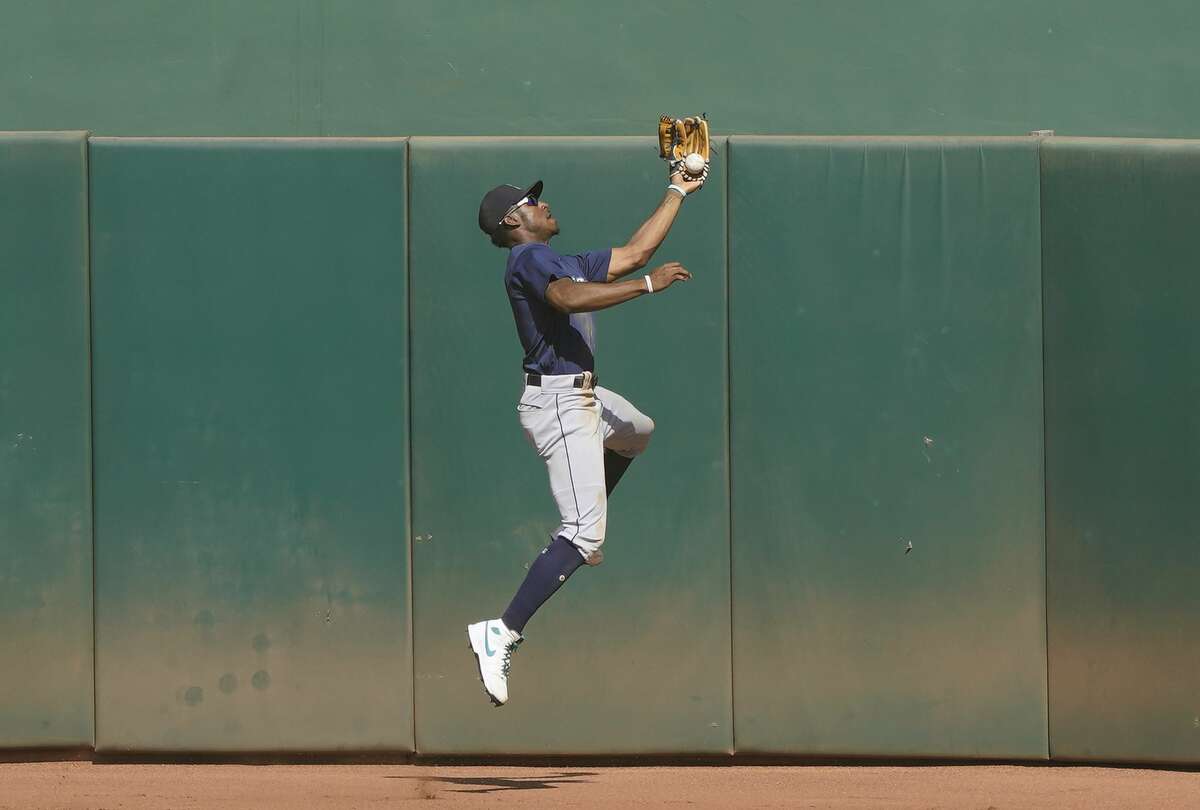 OAKLAND, CALIFORNIA - SEPTEMBER 27: Kyle Lewis #1 of the Seattle Mariners leaps at the wall and can't make the catch of this ball that goes for a bases loaded two-run RBI double off the bat of Mark Canha #20 of the Oakland Athletics in the bottom of the seventh inning at RingCentral Coliseum on September 27, 2020 in Oakland, California. (Photo by Thearon W. Henderson/Getty Images)