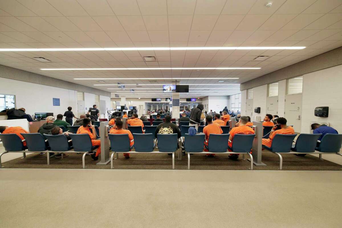 Detainees and inmates wait in the waiting room at the Harris County Joint Processing Center where bail hearings take place on Thursday, Mar. 5, 2020 in Houston.