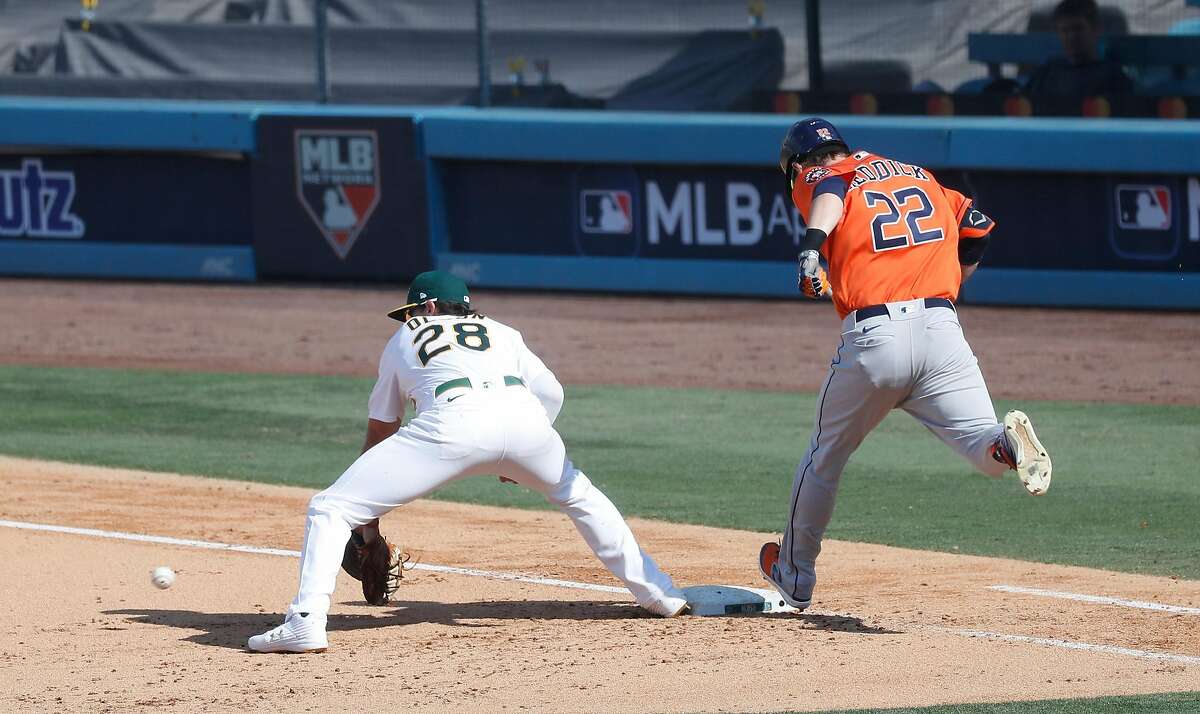 Houston Astros Josh Reddick reaches first base on a fielding error by Oakland Athletics shortstop Marcus Semien during the sixth inning of Game 1 of the American League Division Series, Monday, October 5, 2020, in Los Angeles, at Dodger Stadium.