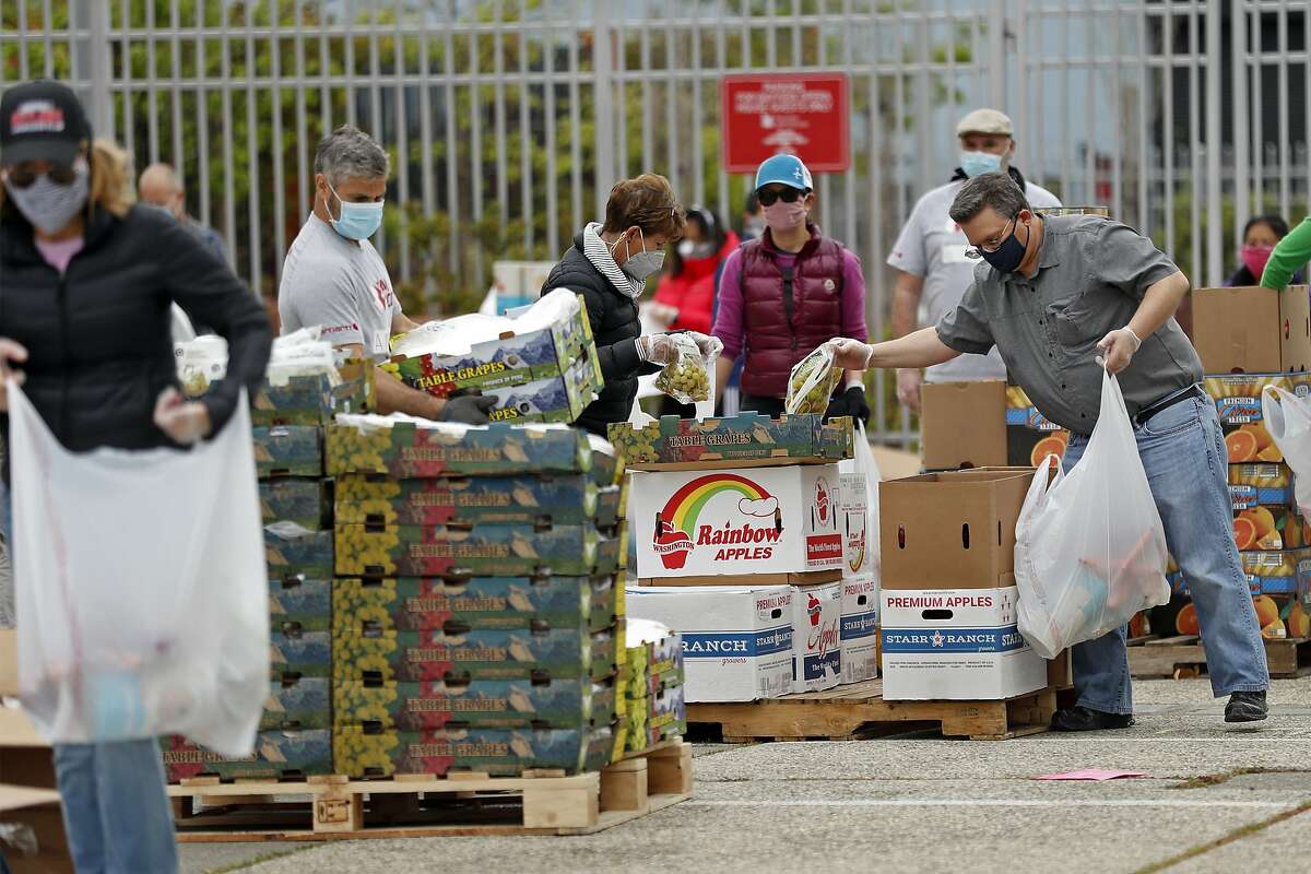 Volunteers assemble some of 1600 food bags that SF-Marin Food Bank distributes at a pop-up pantry at Bayview Opera House in San Francisco, Calif., on Monday, April 20, 2020.
