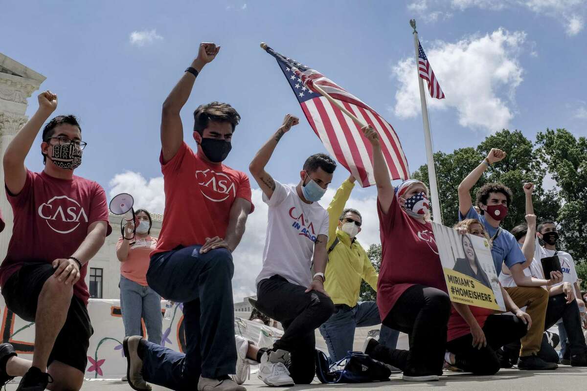 Demonstrators hold their fists in the air while kneeling outside the U.S. Supreme Court in Washington, D.C., U.S., on Thursday, June 18, 2020. A divided U.S. Supreme Court dealt a surprise blow to President Donald Trump, blocking him from ending the Obama-era program that shields 670,000 young undocumented immigrants from deportation and lets them seek jobs. Photographer: Alex Wroblewski/Bloomberg