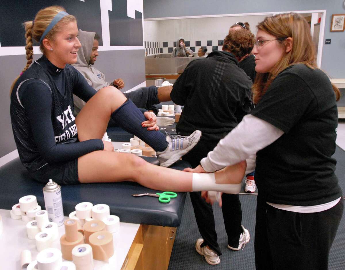 NE11/15/07 4Vicki ML0407A Yale field hockey player and freshman Vicki Gordon left gets her sprained ankle taped by athletic trainer Kelly Copperthite before practice. Photo by Mara Lavitt