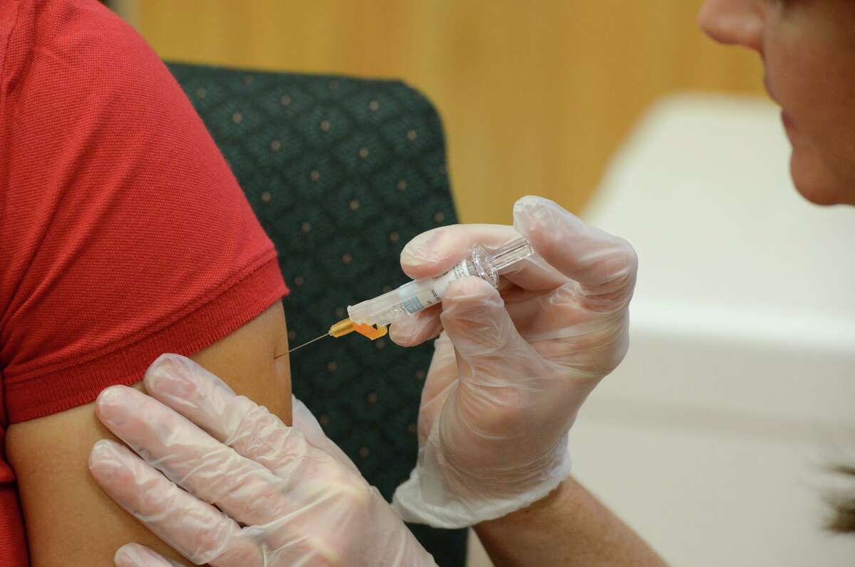 In a Friday, Sept. 16, 2016 photo, a woman receives a flu vaccine shot at a community fair in Brownsville, Texas. Vouchers were provided for many participants at the fair, eliminating the cost associated with the annual vaccination.