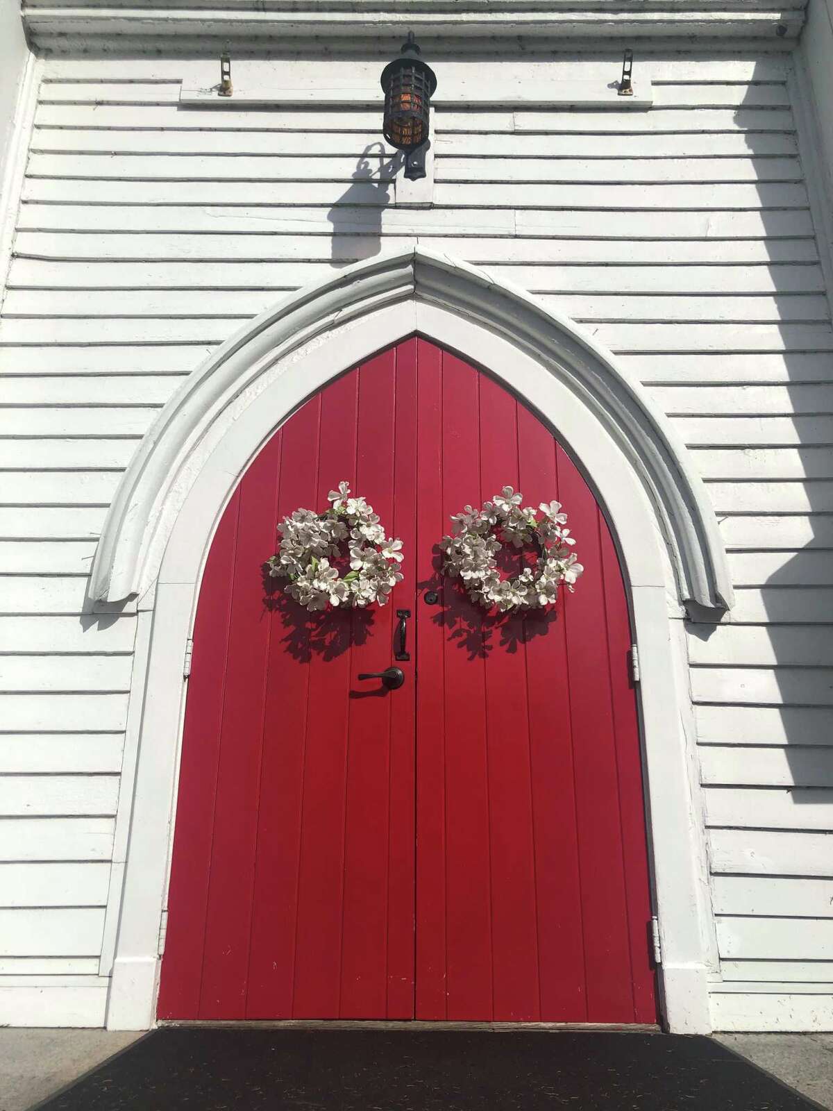 The red door of Christ Church near the intersection of Routes 67 and 317 is striking as motorists pass by.