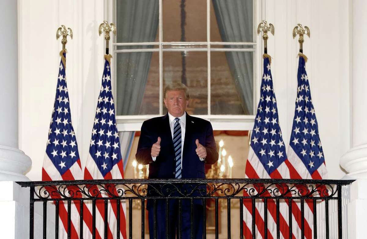 President Donald Trump gives the thumbs-up sign after returning to the White House from Walter Reed National Military Medical Center on Monday.