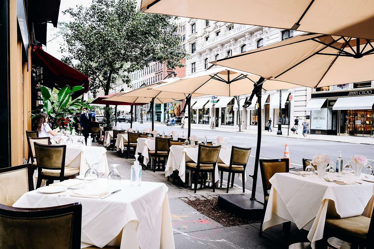 Tables in the outside seating area of a restaurant remain nearly empty during lunch service on Madison Avenue in New York, U.S., on Saturday, Sept. 26, 2020. The pandemic has battered New York City businesses, with almost 6,000 closures, a jump of about 40% in bankruptcy filings across the region and shuttered storefronts in the business districts of all five boroughs. Photographer: Nina Westervelt/Bloomberg
