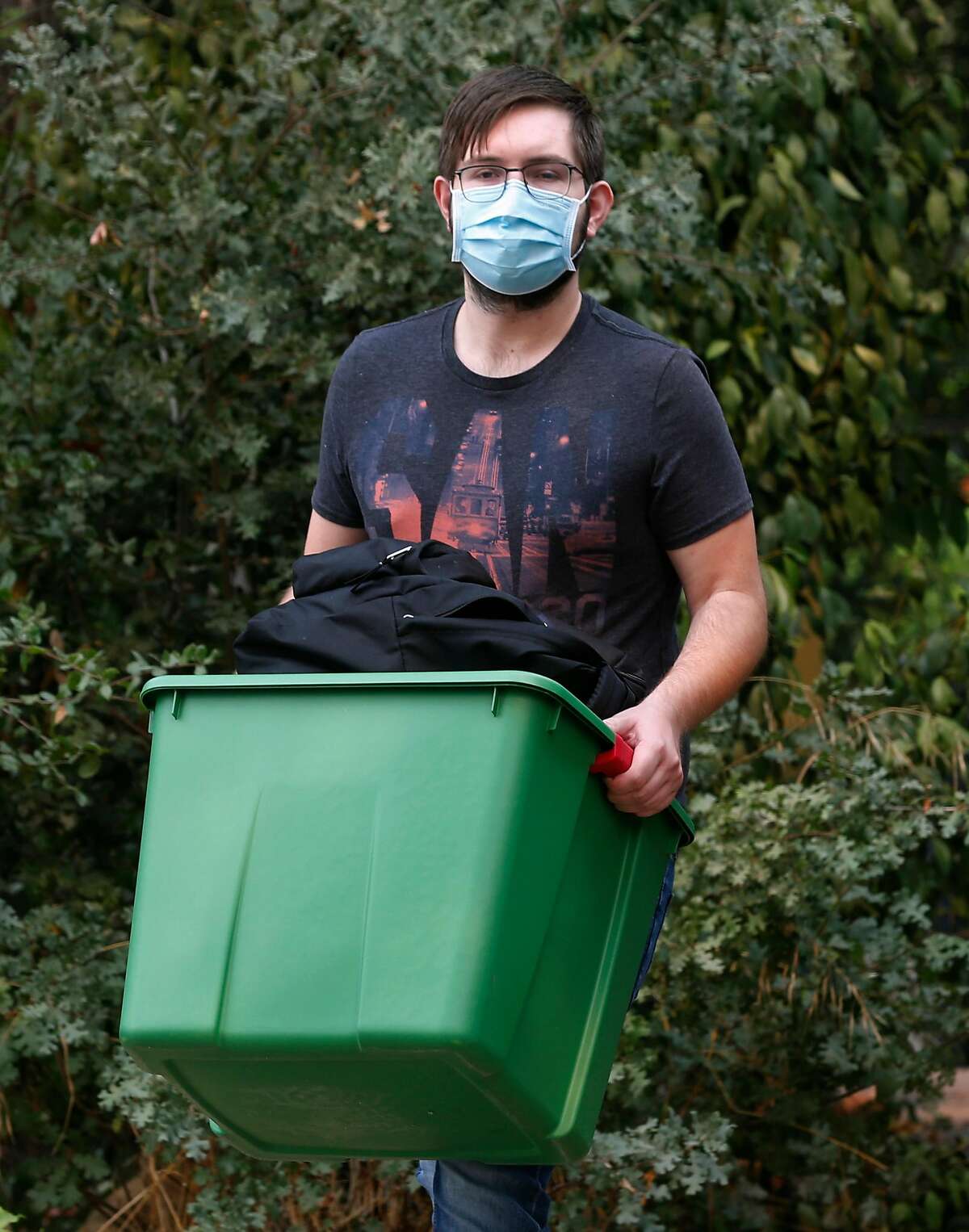 Bobby Hougen carries his emergency go kit from his home to review its contents in Santa Rosa, Calif. on Thursday, Oct. 1, 2020. Hougen has grown tired of always being on alert and ready to evacuate after years of wildfires and is planning to move out of the area.