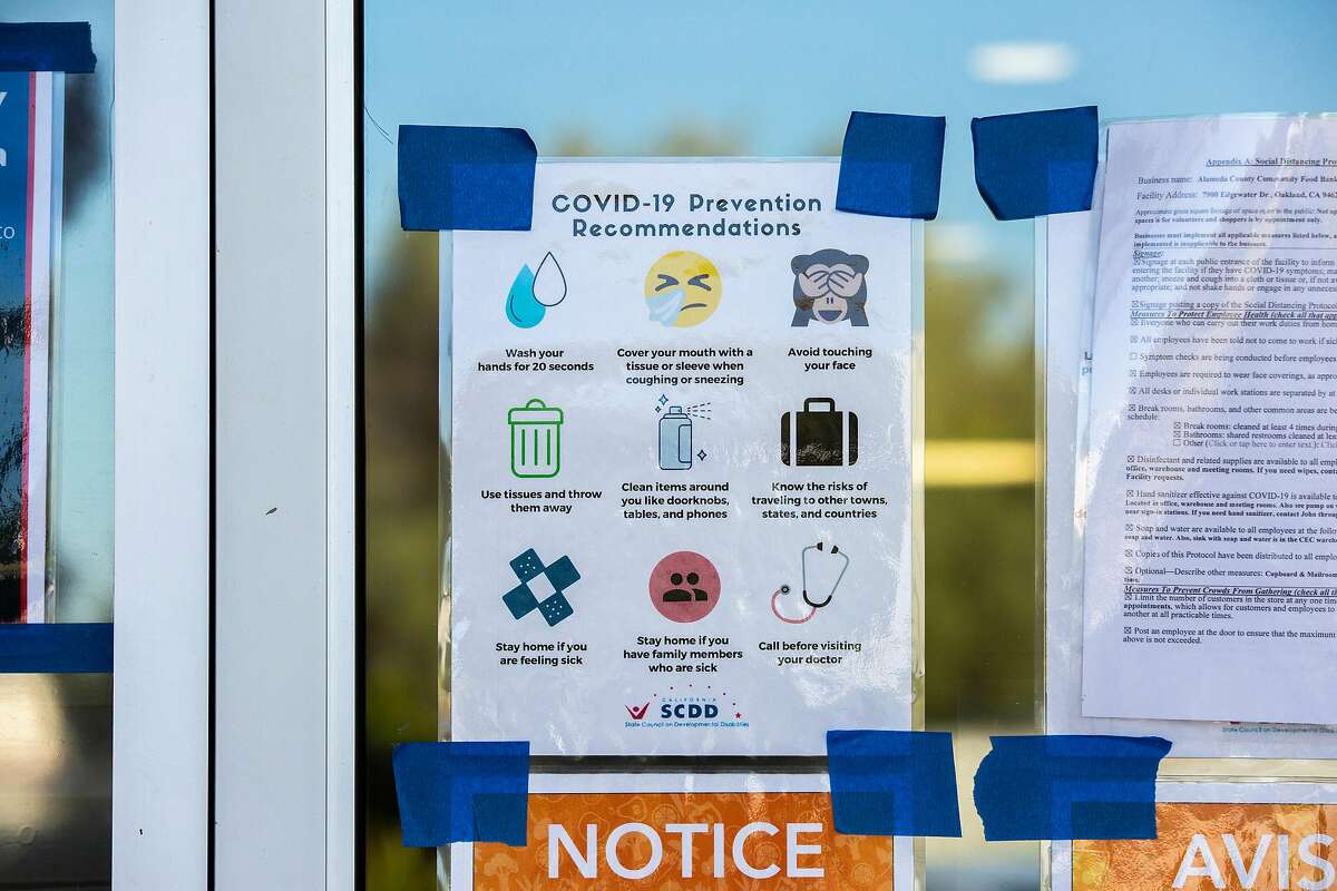 A sign outside the Alameda County Food Bank requiring the use of a face covering before entering the building, Friday, May 22, 2020, in Oakland, Calif.