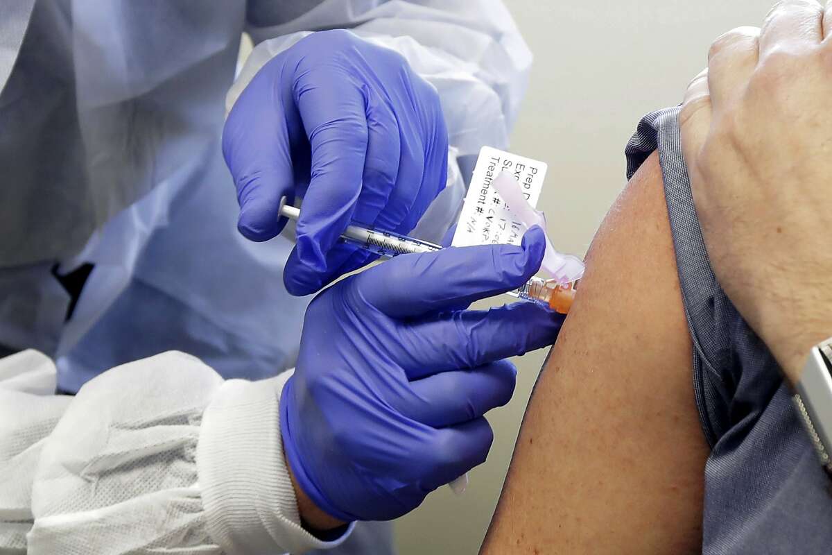 In this March 16, 2020, file photo, Neal Browning receives a shot in the first-stage safety study clinical trial of a potential vaccine for COVID-19 at the Kaiser Permanente Washington Health Research Institute in Seattle.