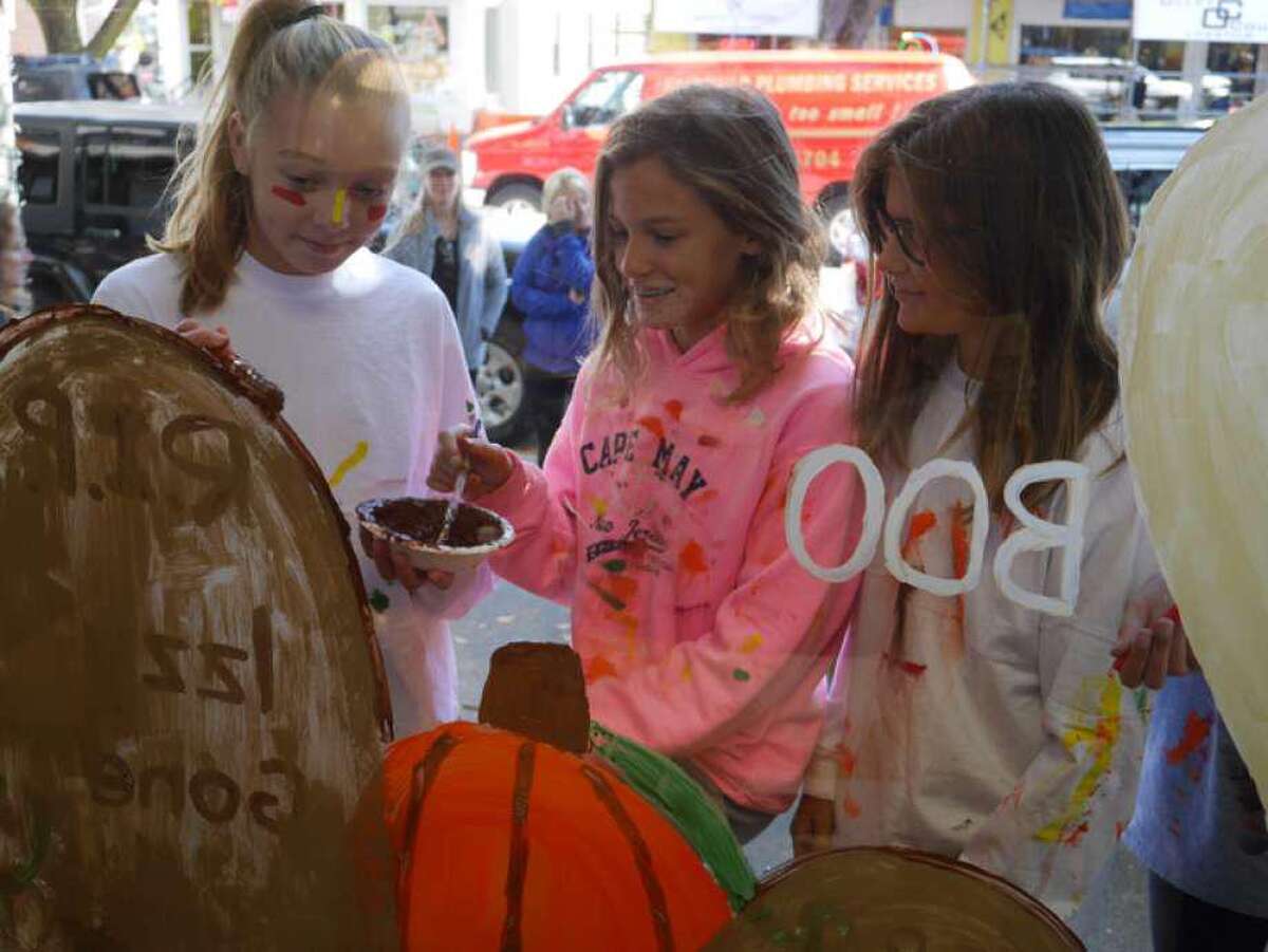 Kids paint windows at a past Halloween Window Painting event hosted by Ridgefield Parks & Recreation.