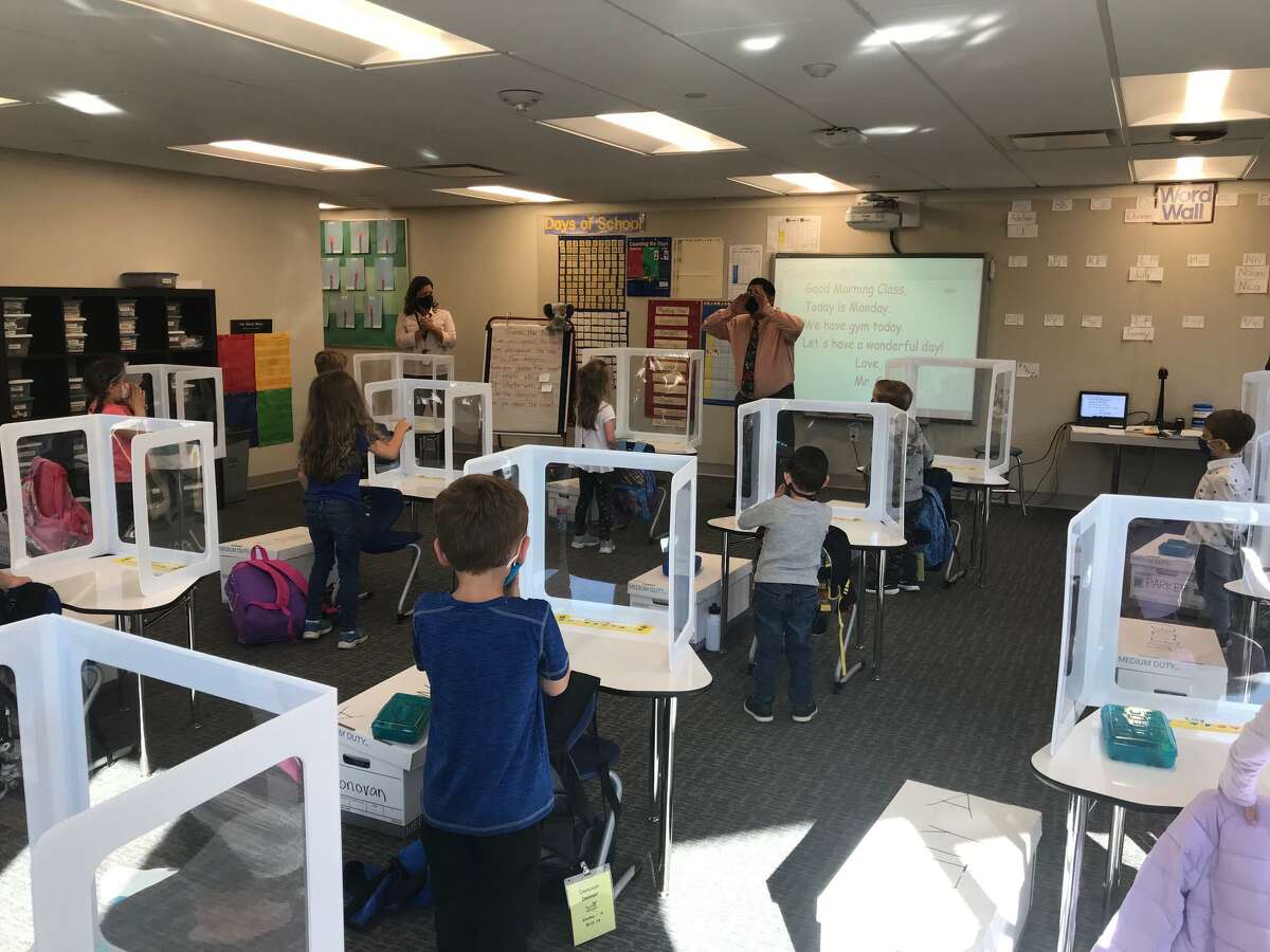 Kindergarten students in Sal Giaimo's class stand at their desks outfitted with sneeze guards. Full kindergarten and first-grade classes returned to Miller-Driscoll School on Monday, Oct. 5.