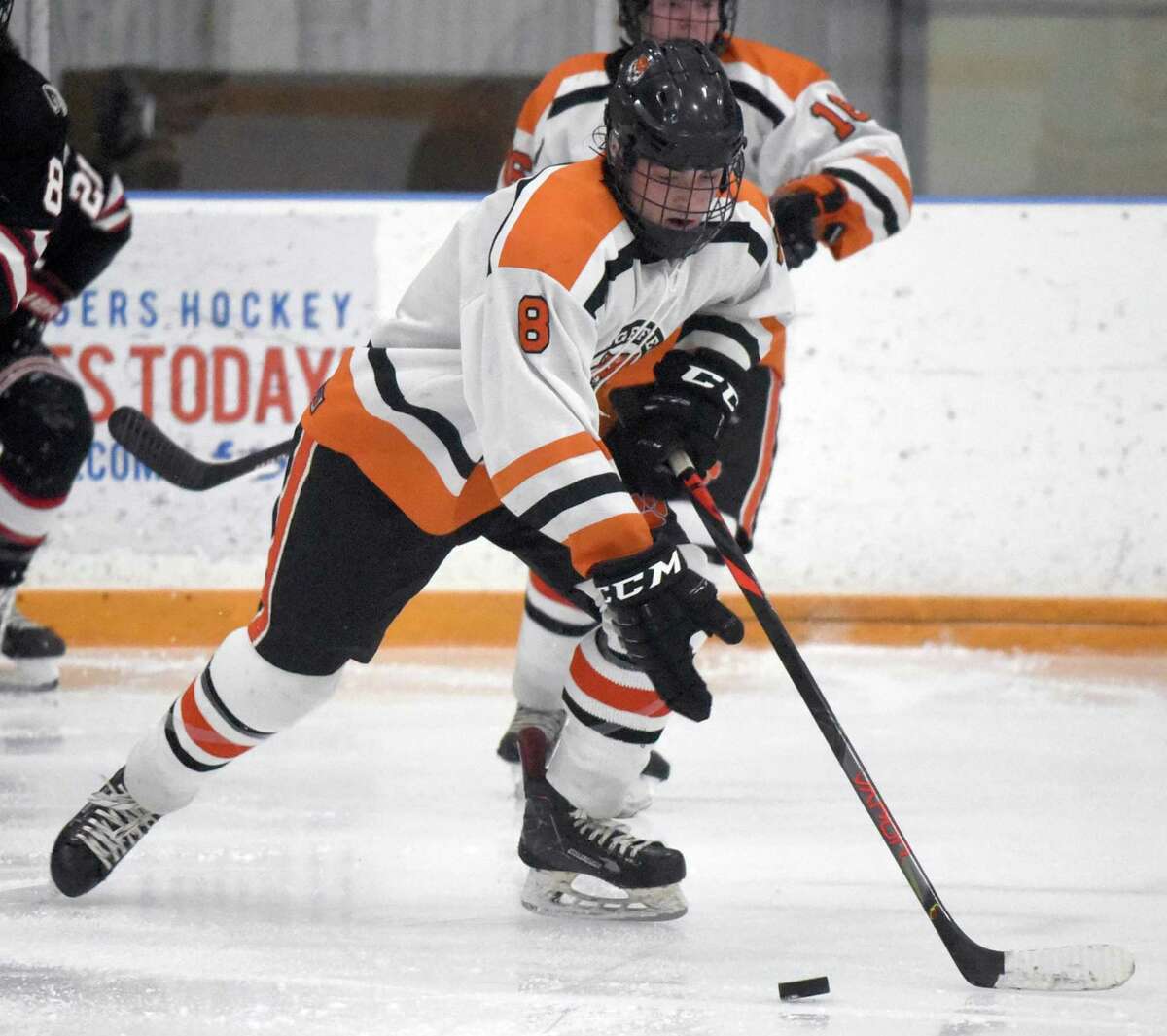 Ridgefield's Kees van Wees (8) skates with the puck during a boys ice hockey game between New Canaan and Ridgefield at the Winter Garden.