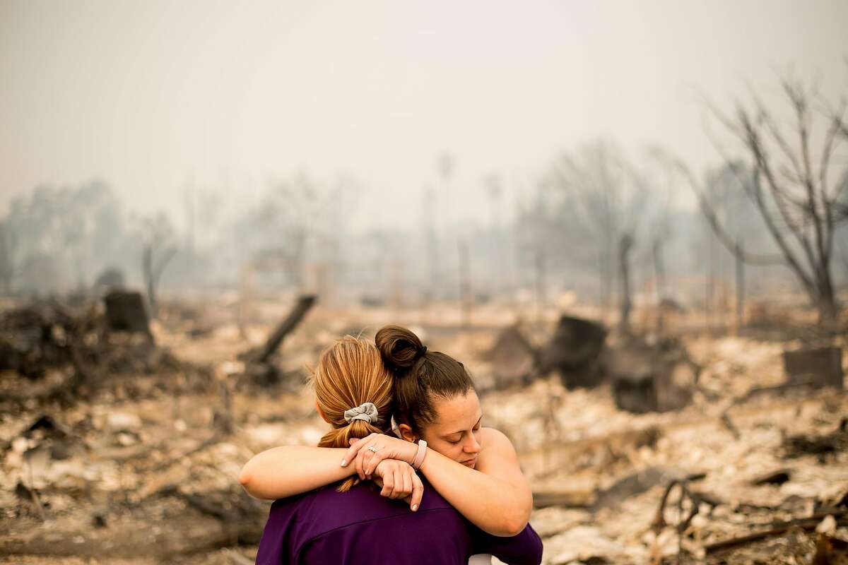 Lori Sarver hugs neighbor Denise Zaleski while searching through the remains of her home in the Coffey Park neighborhood of Santa Rosa, Calif., on Tuesday, Oct. 10, 2017. Both lost their homes as the Tubbs fire roared though the area early Monday morning.