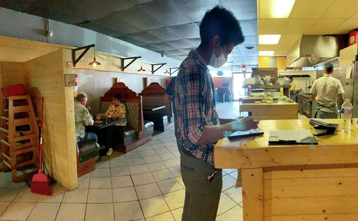 Jonathan Valera processes a customer's order at SoHill Cafe on May 1.