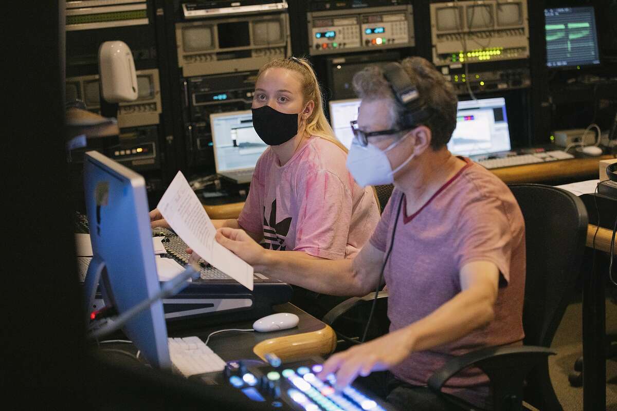 Student producer Emily Brubaker and media production specialist Blasco Felipe work in the television production control room.