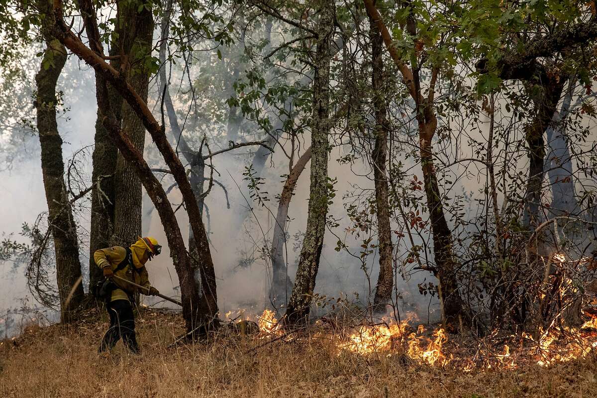 A hand crew monitors a backfire set behind homes to fight the Glass Fire burning along Tucker Road in Calistoga, Calif. Tuesday, September 29, 2020.