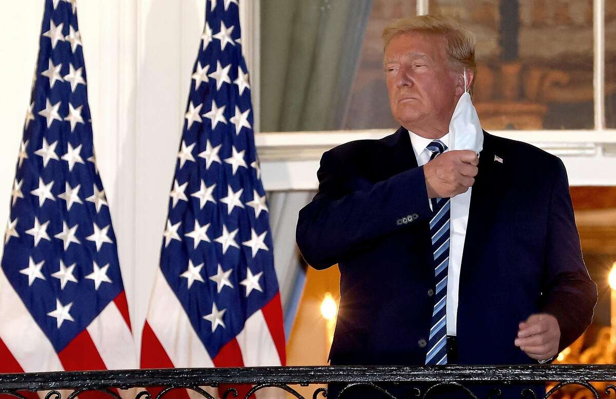 U.S. President Donald Trump removes his mask upon return to the White House from Walter Reed National Military Medical Center on Oct. 5, 2020 in Washington, D.C. Trump spent three days hospitalized for coronavirus. (Win McNamee/TNS)