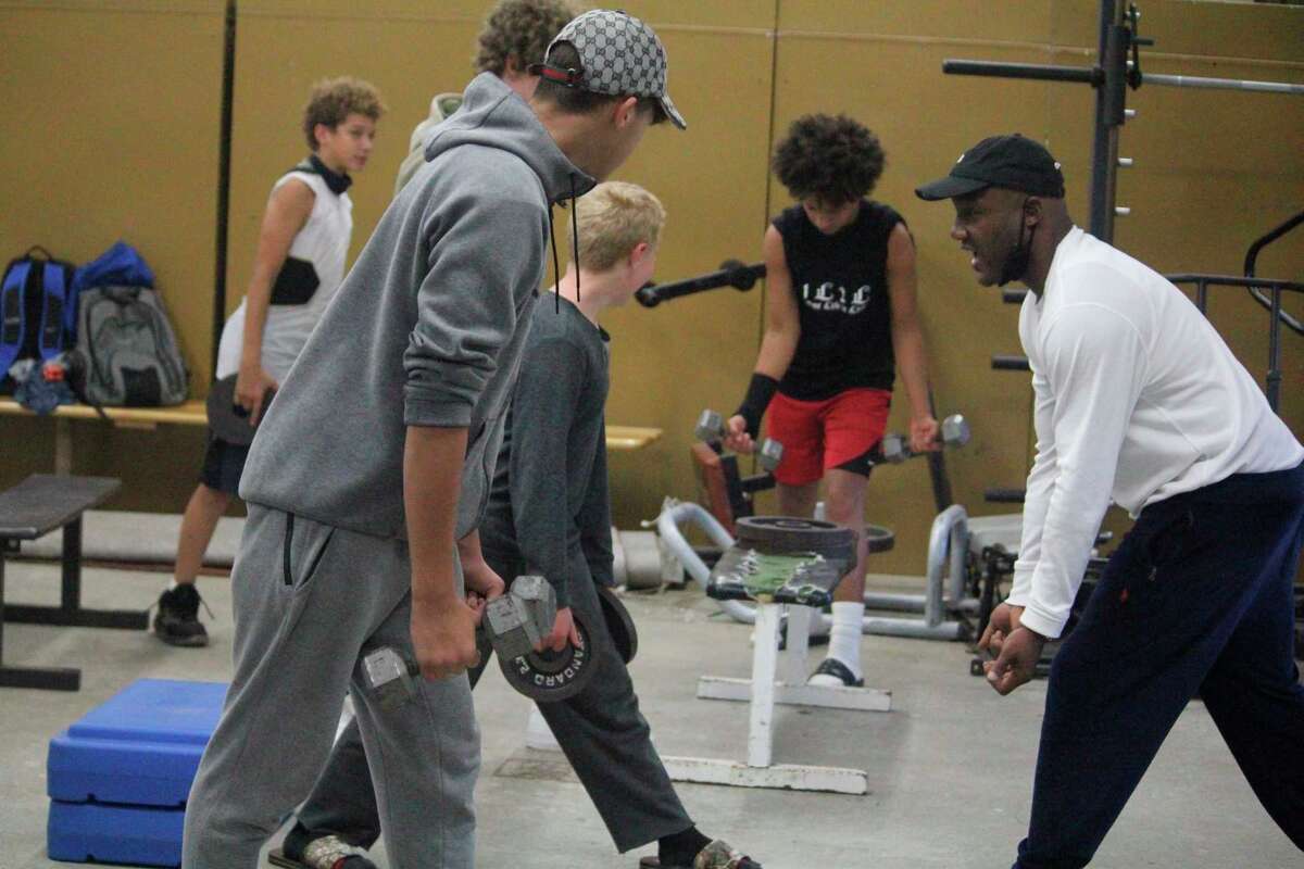 Baldwin assistant coach Shawn Williams (right) leads his players in a weight-lifting workout on Monday in the Baldwin weight room (Star photo/John Raffel)