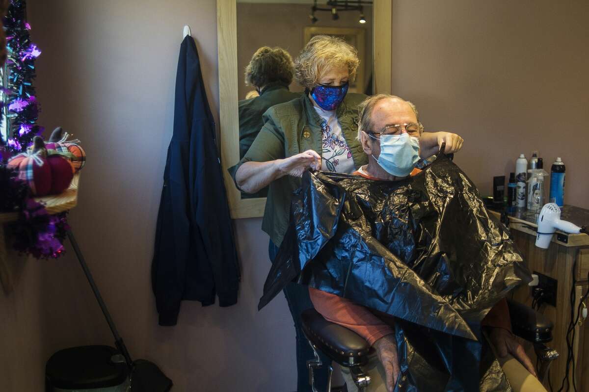 CJ's Hairstyling co-owner Connie Methner gives a haircut to customer Pat Domine as the salon opens for business Thursday, Oct. 8, 2020, for the first time in seven months after being closed first due to the coronavirus and then for renovation after the dam failures and resulting flooding. (Katy Kildee/kkildee@mdn.net)