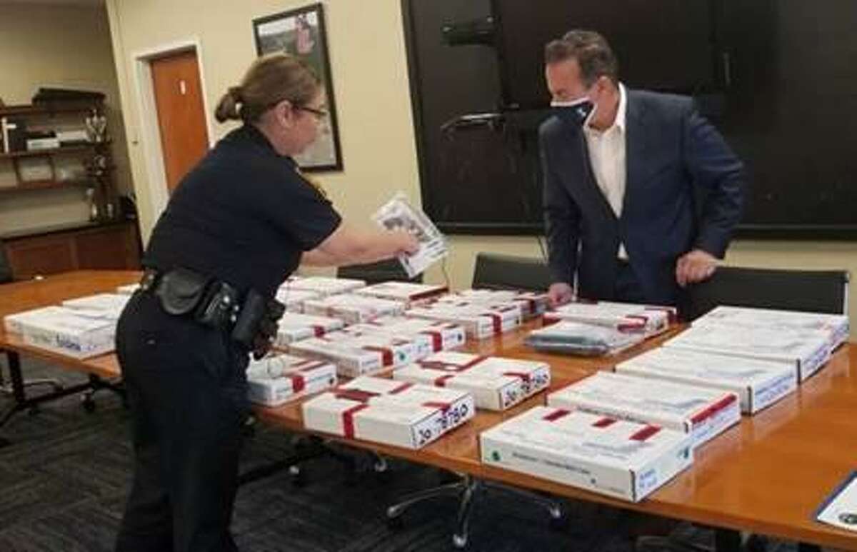 Bridgeport Mayor Joe Ganim inspects more than 30 boxes containing guns city police said they seized in September