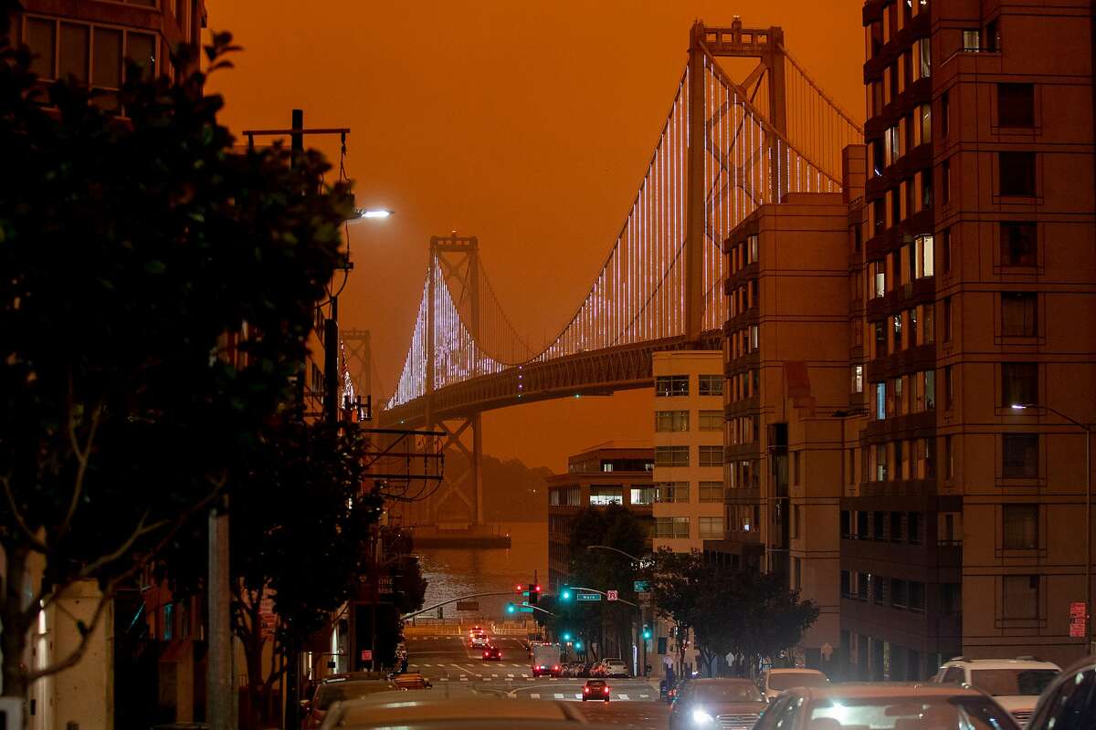 The twinkling Bay Lights on the Bay Bridge are seen illuminated as dark orange skies hang over downtown San Francisco, Calif. Wednesday, September 9, 2020 due to multiple wildfires burning across California and Oregon.