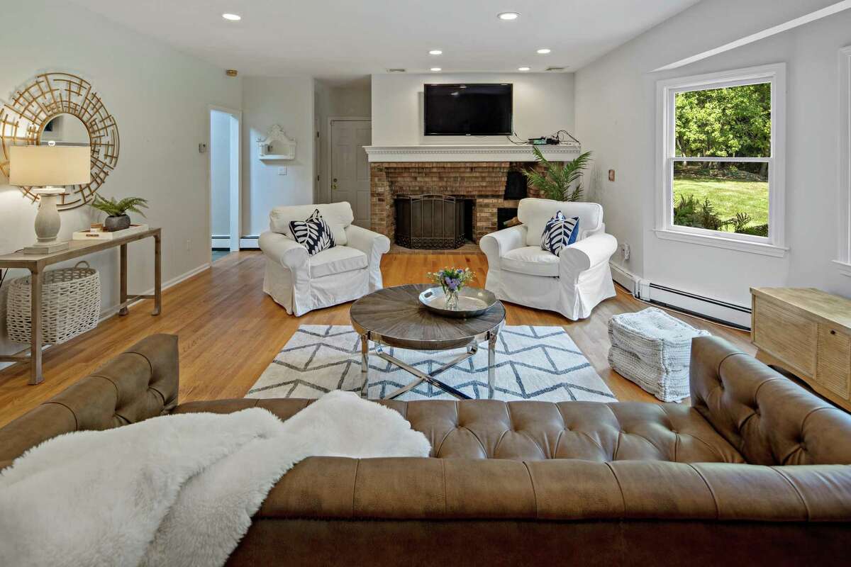 The family room features a red brick fireplace. It sits on a one-acre level and lightly wooded property in the Easton Center neighborhood, convenient to many local amenities and neighboring communities. The backyard features a raised wood deck and a circular paving stone patio with a fire pit, offering great places to sit and relax. And the yard invites old fashioned lawn games as well as more contemporary sporting activities.