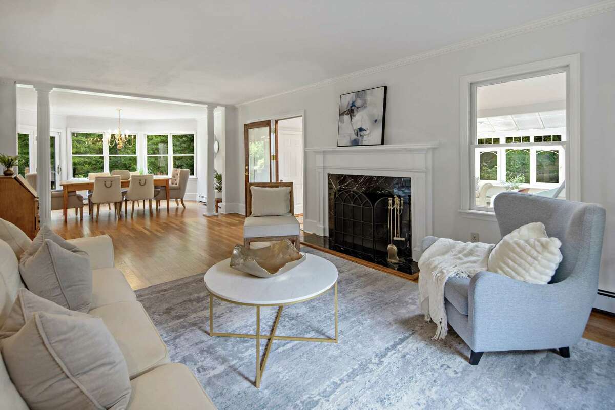 The formal living room has a marble fireplace and two columns separating it from the formal dining room. The Belgium block-lined driveway opens to provide ample parking for family members and guests. A covered walkway with a slate path along the attached two-car garage leads to the casual