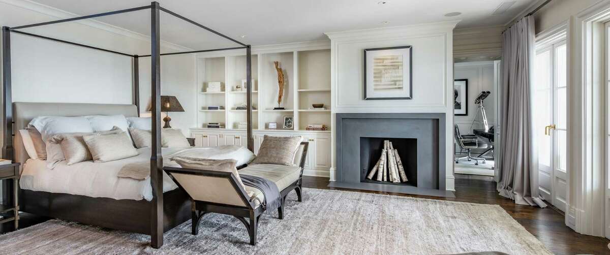 The luxurious master bedroom suite features a fireplace, a wall of built-in shelving and cabinetry, a sitting room or office, private bath, and balcony. It comprises 11,242 square feet of living space and 20 rooms; virtually all with water views. The house is both sturdy and elegant, a mélange of strength and serenity that mimic the sea, according to the listing agent.