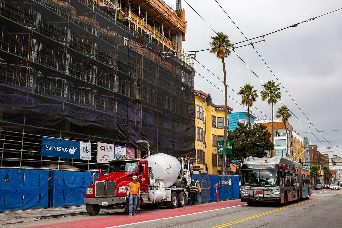 The 14-Mission bus drives past the construction site at 950 Mission St.