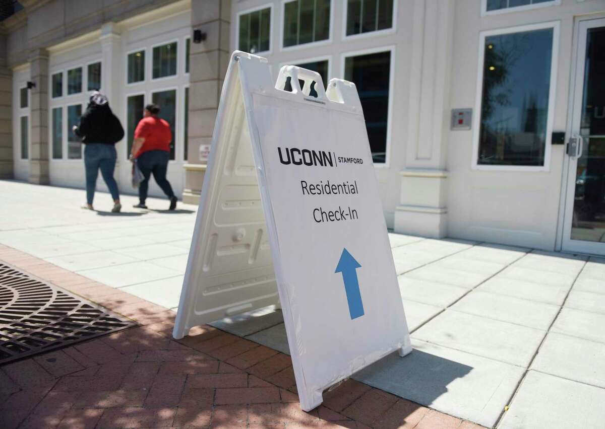 A sign leads to check-in for the student dorms at the UConn Stamford branch in Stamford, Conn. Monday, Aug. 17, 2020. Health experts say active screening for COVID-19 is critical in preventing college outbreaks.