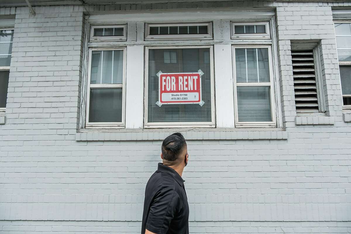 A pedestrian looks at a “For Rent” sign in a window on Hayes Street in San Francisco in October — rents are still low while apartments are still vacant, fallout from the coronavirus pandemic.