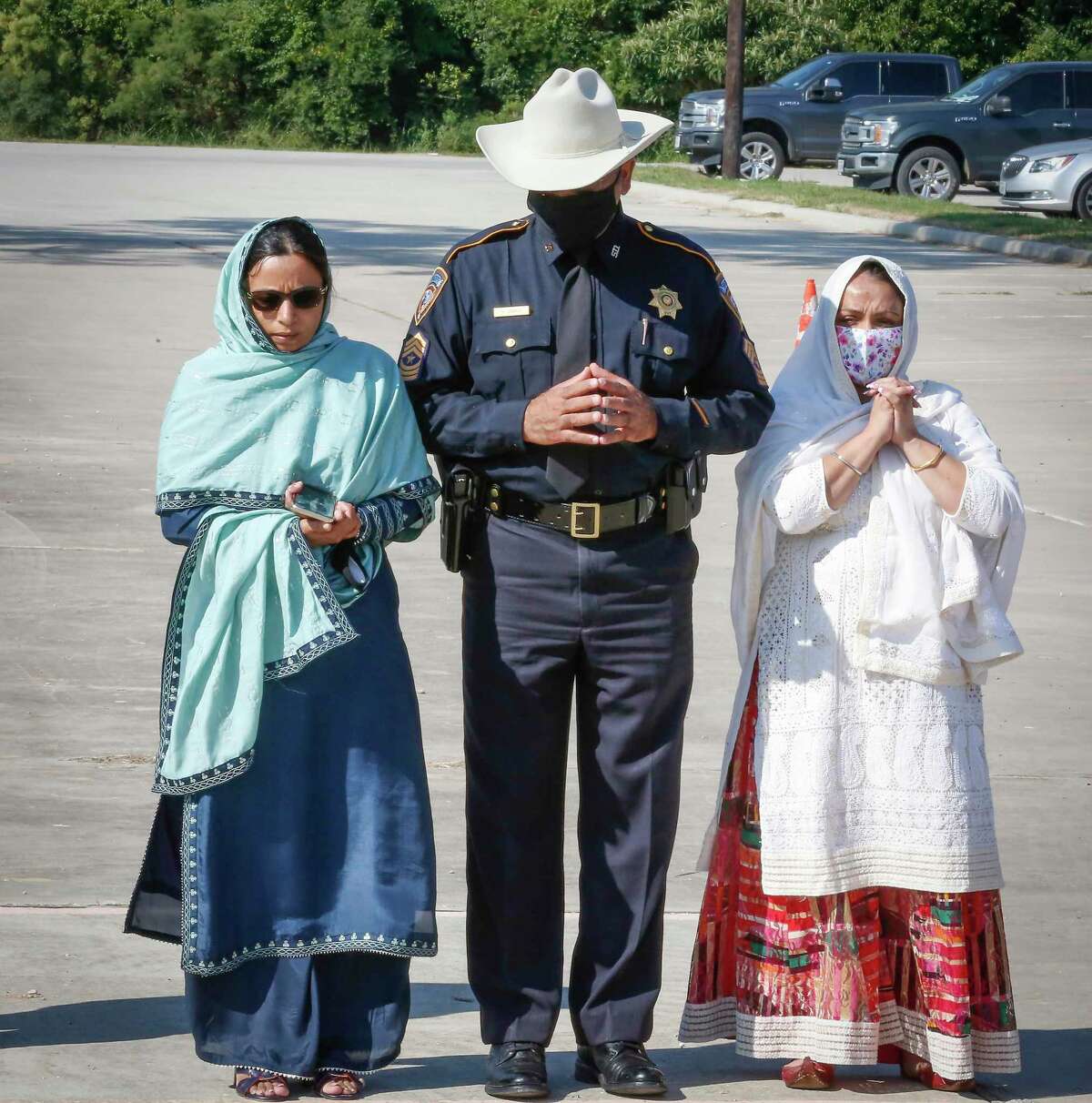 Sheriff Deputy Sandeep Dhaliwal's sisters Harpreet Rai (l), Ranjeet Thandi (r) Harris County Sheriff Sergeant Nasir Abbasi pause during the renaming of a portion of Beltway 8 (between 249 and 290) on the Harris County Toll Road Authority in northwest Harris County in honor of Sheriff Deputy Sandeep Dhaliwal ceremony at Gurdwara Sikh National Center Tuesday, Oct. 6, 2020, in Houston.