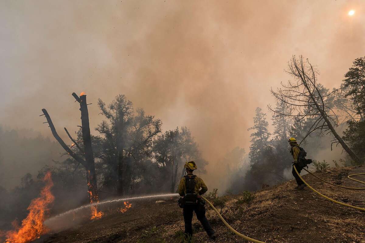 Cal Fire firefighters monitor a controlled burn to fight the Glass Fire near Calistoga. Last weekend, Cal Fire detained a crew of private firefighters for allegedly setting illegal backfires. Fire officials say the number of private firefighting crews is rising, and with it the potential for more conflicts in the fire zone.