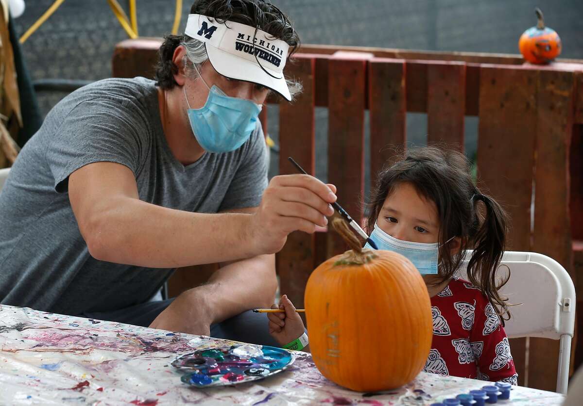 Jordan Danoff, 3, paints a pumpkin with her dad Nick Danoff at the Speer Family Farms pumpkin patch at Telegraph and 19th Streets in Oakland on Saturday. Despite the arrival of fall, little rain is on the near-term horizon.