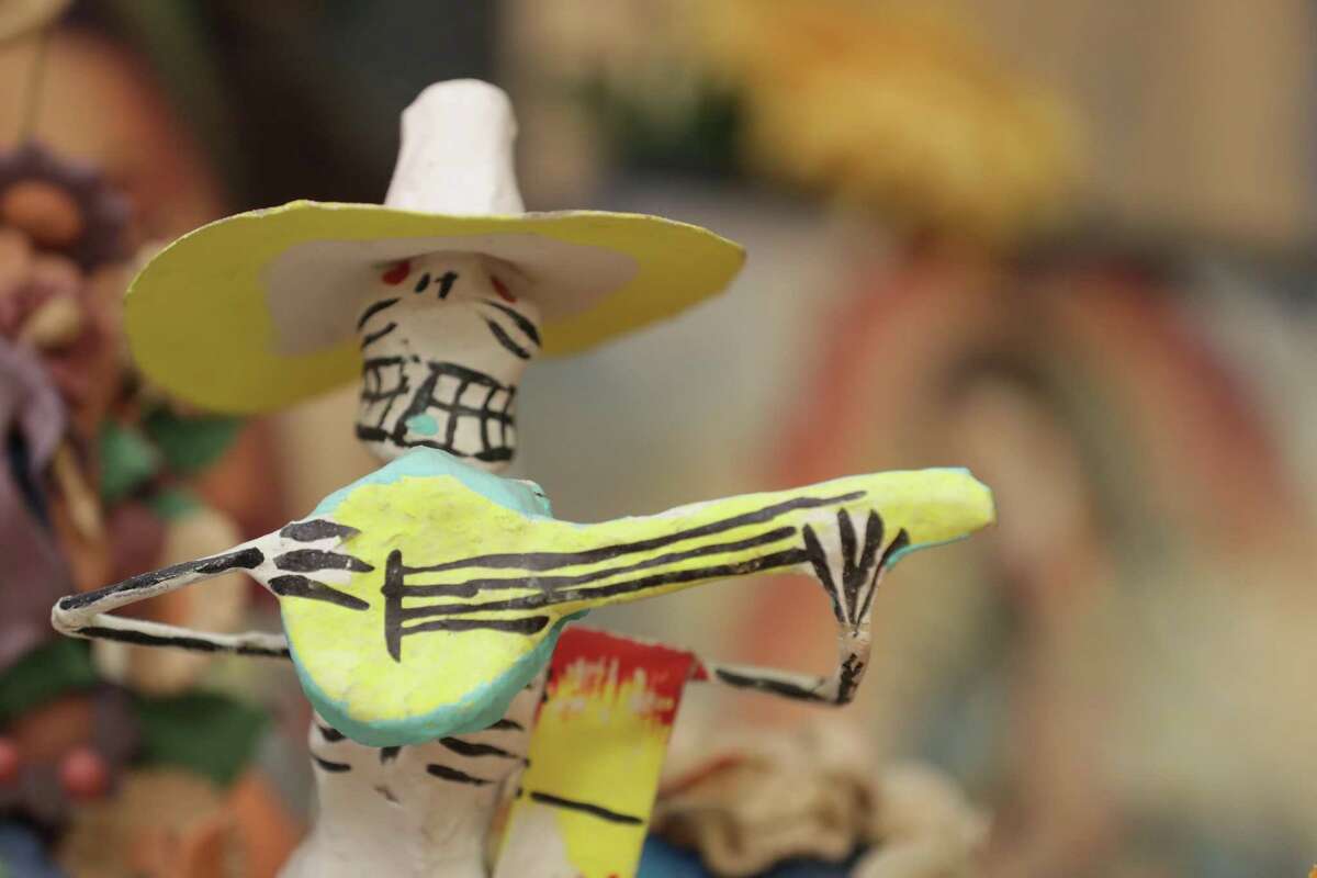 Paper maches skeletons and miniature plastic or clay skeletons are used in Dia de Los Muertos (Day of the Dead) altars Saturday, Oct. 10, 2020, in Houston.