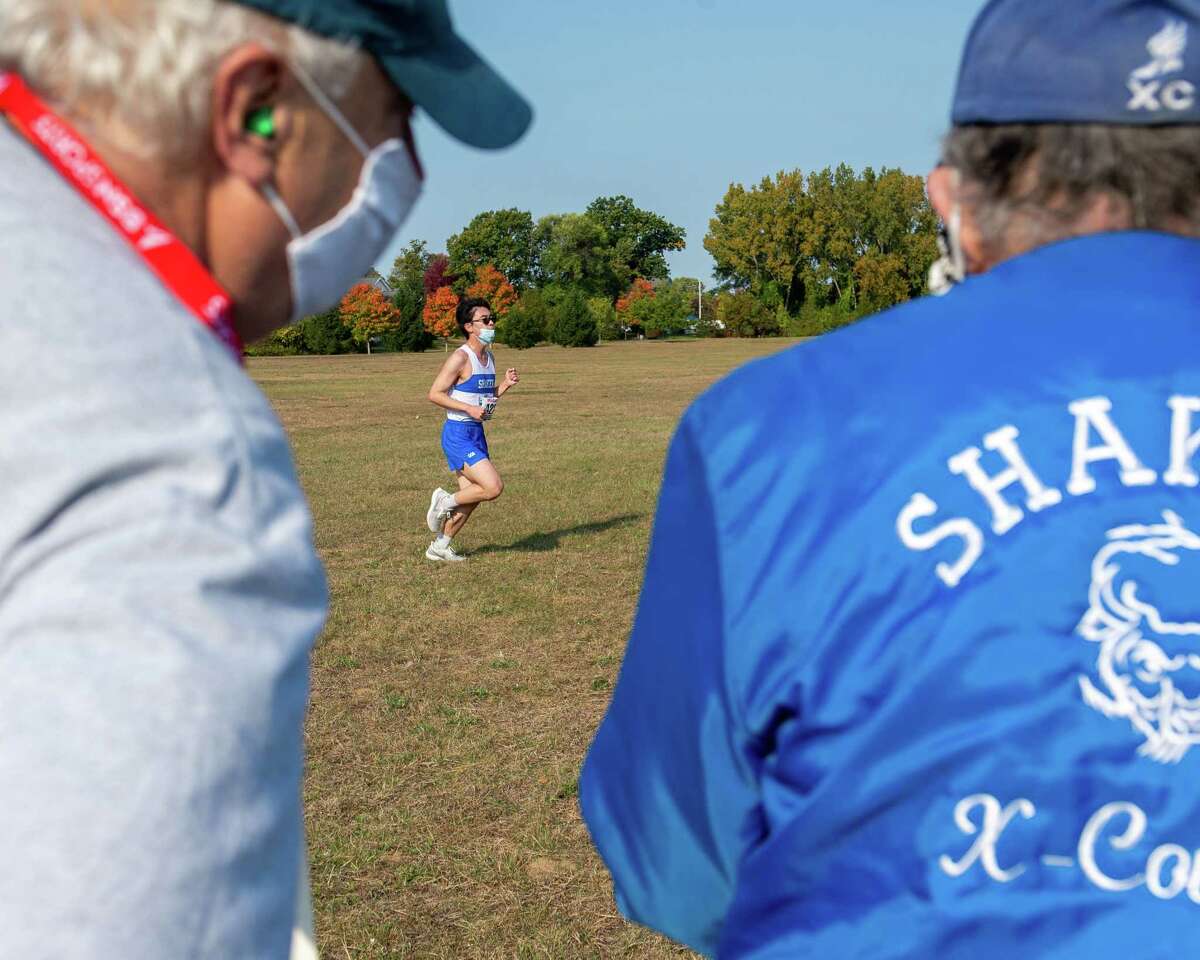 A Shaker High cross country runner passes in front of Jim Libruk and coach Ed Springstead during a race against Burnt Hills Ballston Lake at the Crossings in Colonie, NY, on Saturday, Oct. 10, 2020 (Jim Franco, special to the Times Union.)