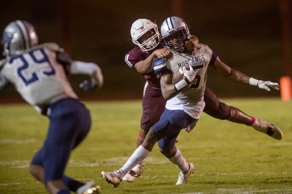 Mustangs Jamaal Shaw (25) is unable to escape the grasp of Tigers Jayron Williams (40). The Mustangs of West Orange-Stark traveled to Silsbee High School to take on the Tigers on Saturday night. Photo made on October 10, 2020. Fran Ruchalski/The Enterprise