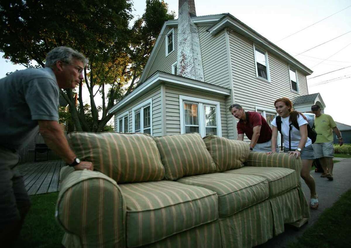 Jim Romanelli, left of Branford, helps his daughter Hollis, 21, a senior at Fairfield University, move a couch to her beachfront rental in Fairfield. Her roomate's father, Jim Gover of Bridgewater, NJ, also helps with move.