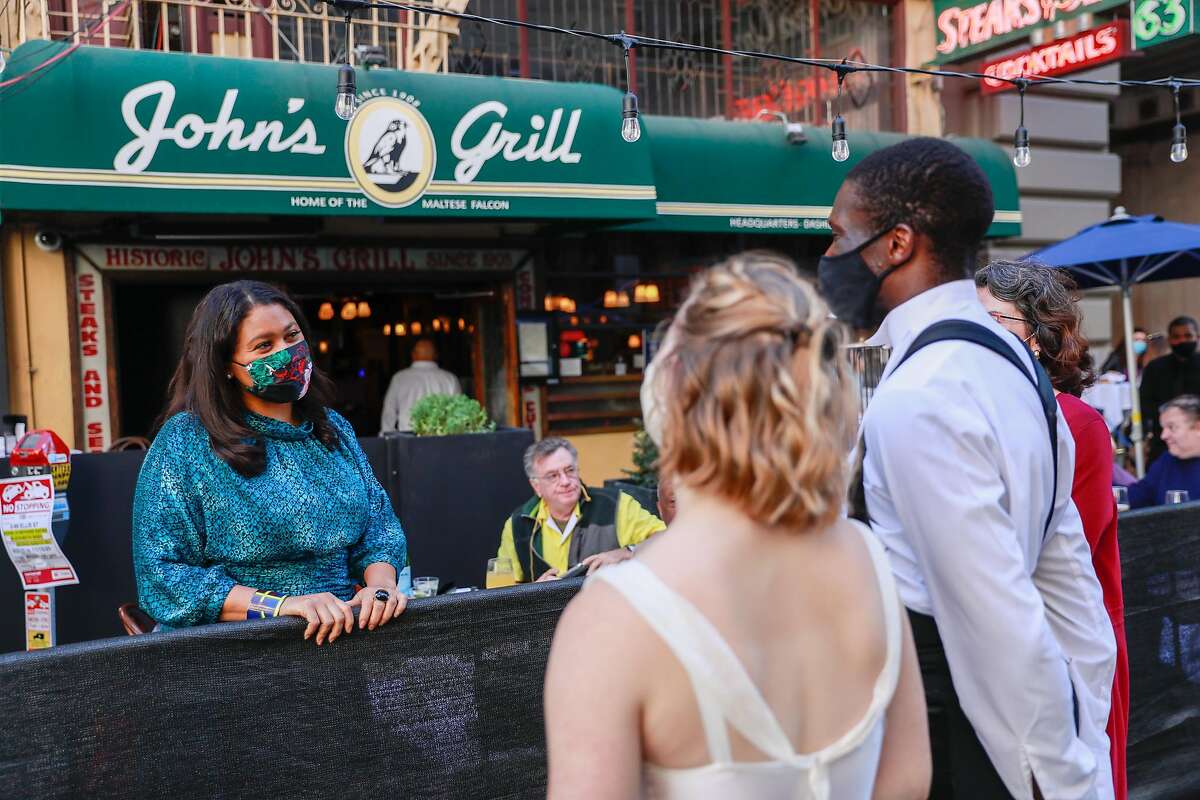 San Francisco Mayor London Breed (left) visits with Smuin Contemporary Ballet dancers Cassidy Isaacson and Brandon Alexander outside John’s Grill.