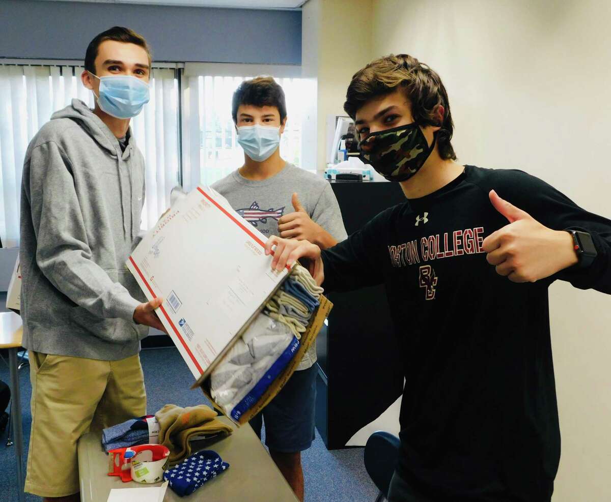 From left, Roen Crameri, Tyler Casey and Eli Ackerman, team leaders for Socks for Soldiers, stuff socks for mailing. The Wilton High School club sends socks for enlisted men and women and veterans to Homes for the Brave in Bridgeport, Kick for Nick in Wilton, and Provisions for Patriots Program in Georgia.