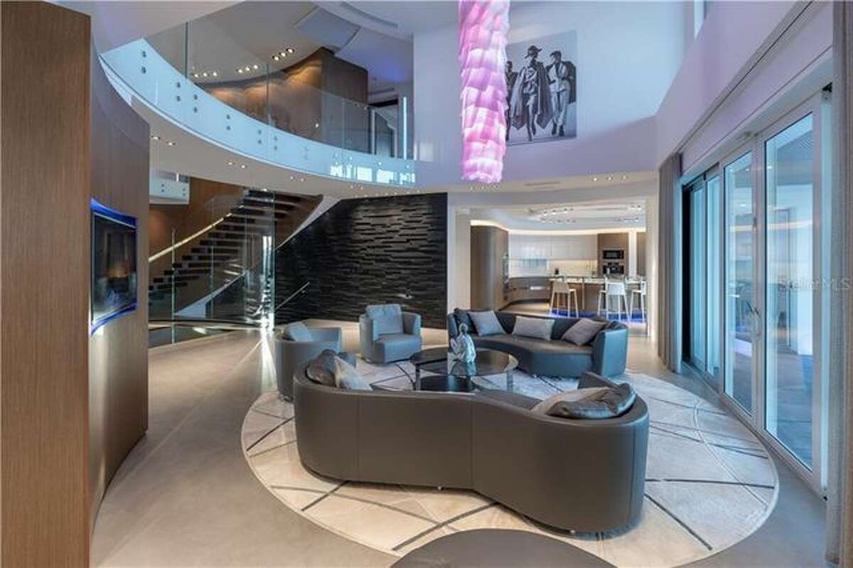 Fully renovated in 2015, the ultramodern abode is set right on the water. The listing details say the home "took over five years to complete." It features sleek built-ins, mood lighting, and chandeliers that drip from the ceiling like stalactites. Materials used in the construction include glass, stone, quartz, and wood. On 8,400 square feet, the layout features five bedrooms, five en suite bathrooms, and three half-bathrooms, spread over three floors. The generous master suite overlooks the water, adjacent to a home gym. The living areas include a formal living room, dining room, theater, and wet bar, as well as a billiard-room with a fireplace.