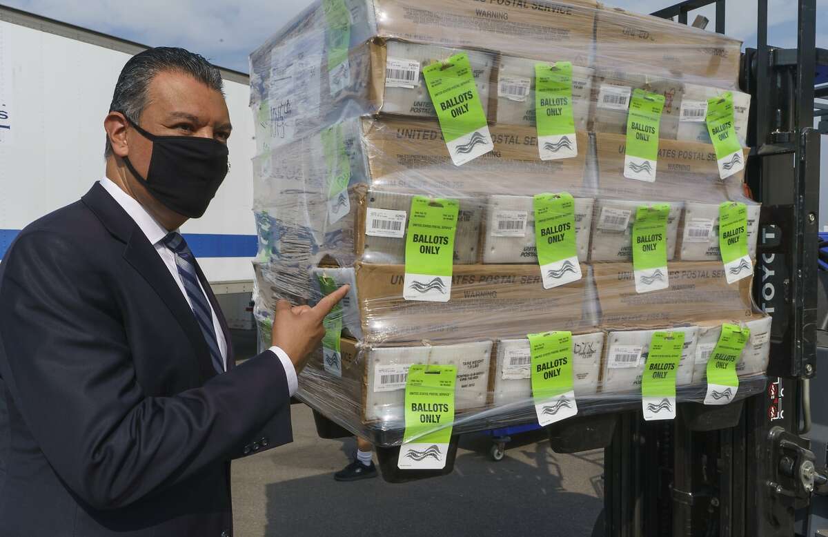 California Secretary of State Alex Padilla stands next to a pallet with ballots on Oct. 5 in Santa Ana.
