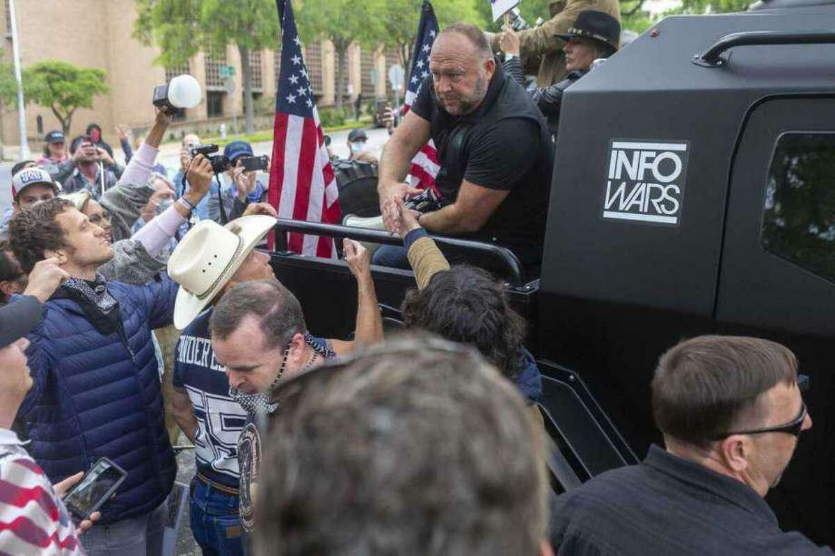Alex Jones greets supports as he exits a protest at the Texas Capitol in Austin looking to end to the coronavirus shutdowns, Saturday, April 19, 2020.