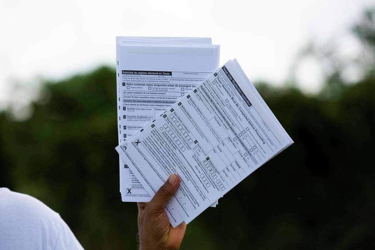 Muhammed Nasrullah, 68, hold Texas voter registration applications for distribution at a food distribution event, Friday, Sept. 25, 2020, in Houston. Nasrullah has been a voter registrar since 2004.