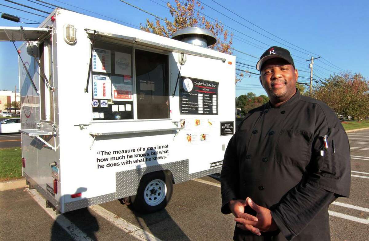 Melvin Riley poses in front of his food truck Riley’s Kitchen, parked at Kohl’s parking lot in Orange, Conn., on Tuesday Oct. 6, 2020. Riley operates the truck with his wife, Tanya.