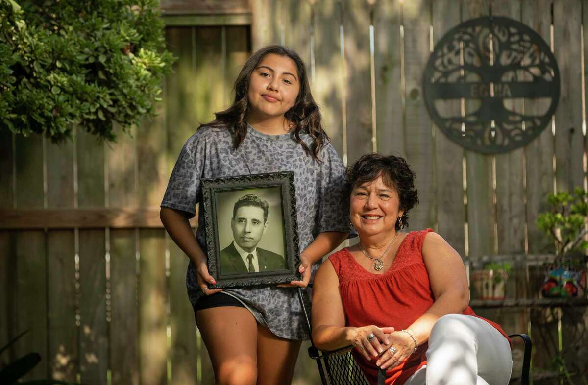 Addison Marie Curry, 13, and her grandmother Rebecca Eguia hold a photo of Rebecca's father, Ernest Eguia, Saturday, Sept. 26, 2020, in Houston. Eguia was a World War II veteran who served in various roles with LULAC for almost 70 years. Addison was in awe when she saw a photo of her great-grandfather presented in her Texas history class.